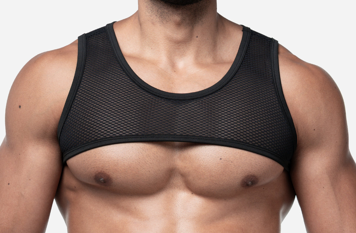 A close-up of a man's chest wearing a black mesh underboob band, shown against a plain light gray background.  The brand name is PUMP.